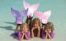 沙滩美人三个小女孩在海边沙滩上扮演美人鱼图片